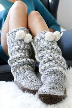 a woman is sitting in a chair with her feet up wearing crocheted slippers