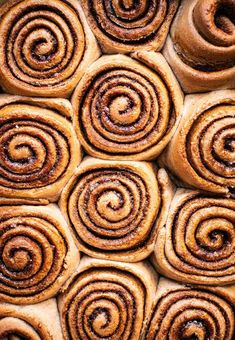 many cinnamon rolls are stacked on top of each other in the shape of spirals