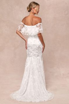 a woman in a white wedding dress with off the shoulder sleeves and an open back