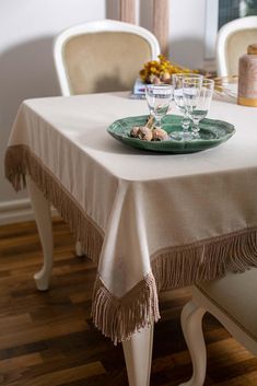 the table is set with two wine glasses and a green plate on top of it