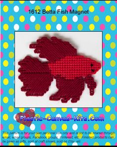 two red knitted fish magnets sitting on top of a blue and white polka dot background