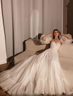 a woman in a wedding dress sitting on a couch with her arms behind her head