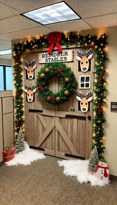 an office decorated for christmas with wreaths and reindeer heads on the front door, surrounded by lights