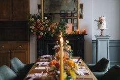 a dining room table is set with flowers and candles