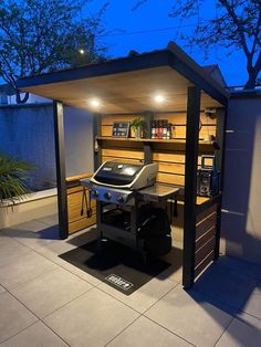 an outdoor bbq grill area with lights on the side and shelves above it that are built into the wall