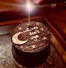 a birthday cake with the words witches don't go on it and a lit candle