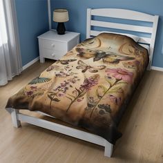 a bed in a room with blue walls and wooden flooring that has a butterfly print on it