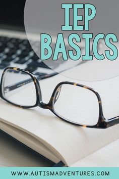 an open book with glasses on top of it next to a laptop