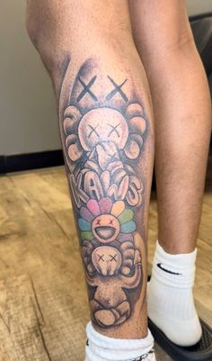 a man's leg with a tattoo on it that has a teddy bear holding a candy bar