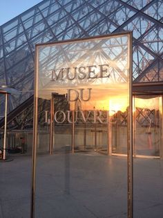 the sun is setting in front of a glass building that says museum du jouyre