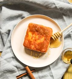 a piece of bread on a plate with honey