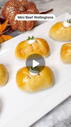 mini bee wellingtons on a white platter with orange pumpkins in the background