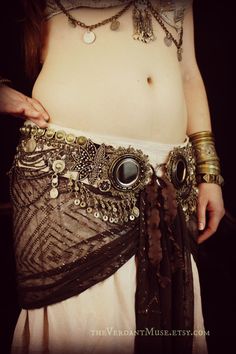 a close up of a person wearing a belt with beads and chains on it's waist