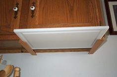 an overhead view of a kitchen cabinet with wood trim on the door and bottom panel