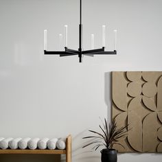 a black chandelier hanging from a ceiling in a living room with white walls