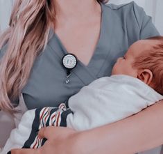 a woman holding a baby in her arms with a watch on it's wrist