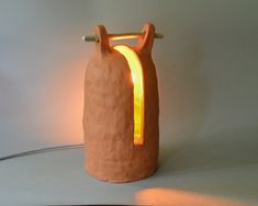 a light that is on top of a table next to a vase with a handle