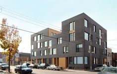 the cars are parked on the side of the road in front of two buildings with windows