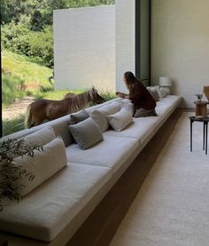 a woman sitting on a couch in front of a window