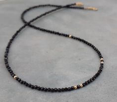 Super dainty black spinel and gold necklace/chocker,anniversary wife gift 2mm genuine faceted black spinel beads with 14k solid yellow gold beads(6 beads) and 14k solid gold clasp. Can be worn alone for the minimalist look or layered with other necklaces Please select your prefered length and your prefered clasp (spring or fish lock) befor checkout ! Materials: 2mm black spinel faceted beads 14k solid gold Minimalist Black Jewelry With Faceted Beads, Black Spinel Necklace, Spinel Necklace, Wedding Necklace Set, Chocker Necklace, Black Beaded Jewelry, Black Bead Necklace, Wife Gift, Black Spinel