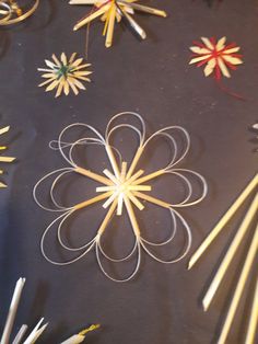 several different types of sticks are arranged on a table with paper flowers and pencils