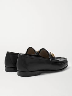 Gucci's iconic loafers were first introduced in 1953; it says a lot about the timelessness of the design that they've barely changed since. This glossy black version has been crafted in Italy from leather embellished with the hallmark horsebit that nods to the brand's equestrian heritage. Gucci Formal Slip-on Leather Shoes, Gucci Slip-on Formal Leather Shoes, Luxury Moccasins With Leather Footbed, Luxury Moccasins With Leather Footbed For Galas, Luxury Formal Loafers With Leather Footbed, Luxury Leather Loafers With Leather Footbed For Formal Occasions, Timeless Gucci Slip-on Loafers, Classic Formal Loafers With Horsebit Detail, Gucci Formal Loafers With Horsebit Detail