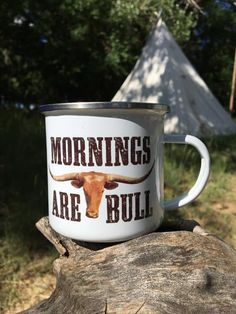 a coffee mug with the words mornings are bull on it sitting on a tree stump