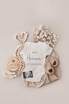 a baby's personalized onesuit and other items are laid out on the floor