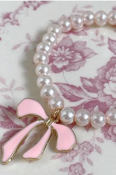 The most precious summer accessory ~ cute as can be and the perfect pop of pearl! Name a better accessory to your LoveShackFancy pieces. Handmade One size fits most ~ elastic band Pearl bracelet with charm detail Bday Aesthetics, Pearl Name, Cowgirl Era, Luv Aj, Vintage Havana, Pink Bracelet, Summer Accessories, For Love And Lemons, Pink Ribbon