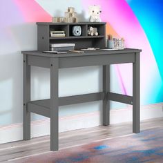 a desk with a book shelf on top of it in front of a colorful wall