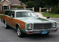 an old station wagon parked in front of a house