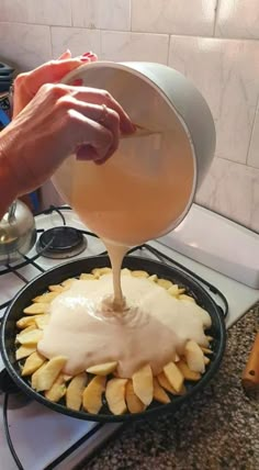 someone is pouring liquid on some food in a frying pan that has cut up apples