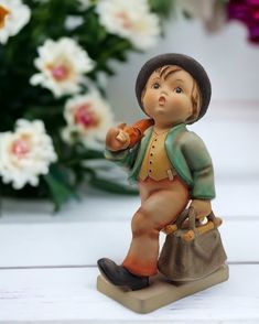 a figurine of a little boy holding a purse