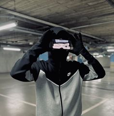 a person wearing a hoodie and covering their eyes