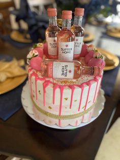 a cake that has some bottles on top of it and pink icing around the edges