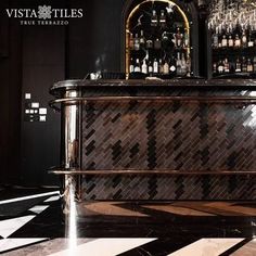 a bar with several bottles on it and a black and white checkerboard floor