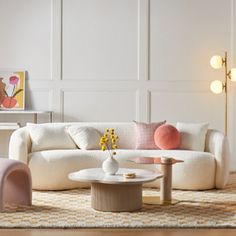 a living room filled with white furniture and lots of pillows on top of it's couches