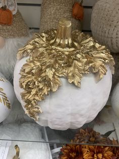 white pumpkins with gold leaf decorations on display