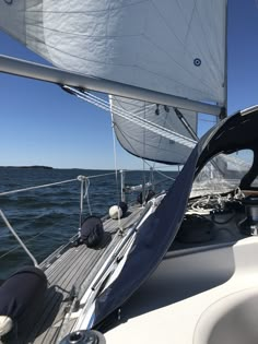 a sailboat sailing on the water with its sails down and it's head in the foreground