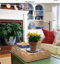 a living room filled with furniture and a fire place next to a fireplace covered in blue and white plates