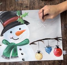 someone is painting a snowman with ornaments