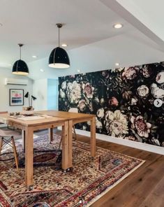 a dining room table and chairs in front of a large floral wallpapered background