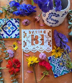 flowers and cards on a table with the number thirteen printed in white, surrounded by cut outs