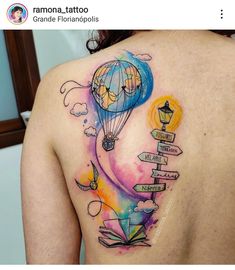 the back of a woman's shoulder with a colorful tattoo on her left side