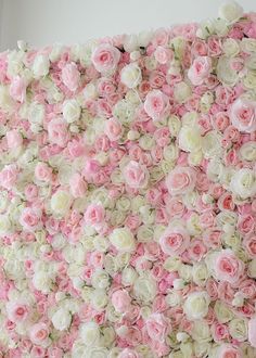 pink and white flowers are arranged on the wall