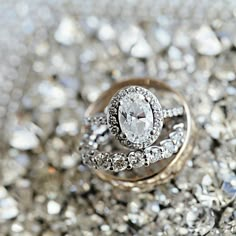 a diamond ring sitting on top of a pile of diamonds