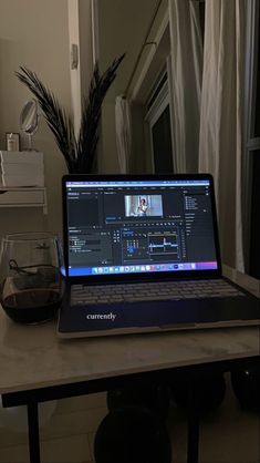 an open laptop computer sitting on top of a white table in front of a window