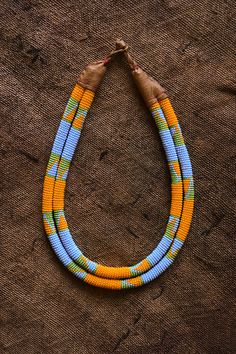 This African Tribal Necklace is a timeless piece of jewelry crafted with quality. Featuring a beaded collar design, it is sure to make a statement. The intricate craftsmanship and vibrant colors make it the perfect addition to any wardrobe Length: 10 inches Bohemian Multicolor Bib Necklace With Tiny Beads, Traditional Multicolor Wooden Beaded Necklaces, Traditional Multicolor Wooden Beaded Necklace, Yellow Handwoven Bohemian Beaded Necklace, Bohemian Yellow Handwoven Beaded Necklace, Artisan Yellow Beaded Necklaces Handwoven, Traditional Handwoven Yellow Beaded Necklaces, Traditional Yellow Handwoven Beaded Necklaces, Yellow Handwoven Artisan Beaded Necklaces