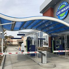 the entrance to a car wash with blue and white awning