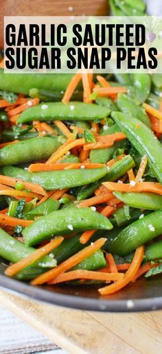 garlic sauteed sugar snap peas in a pan with carrots and green beans